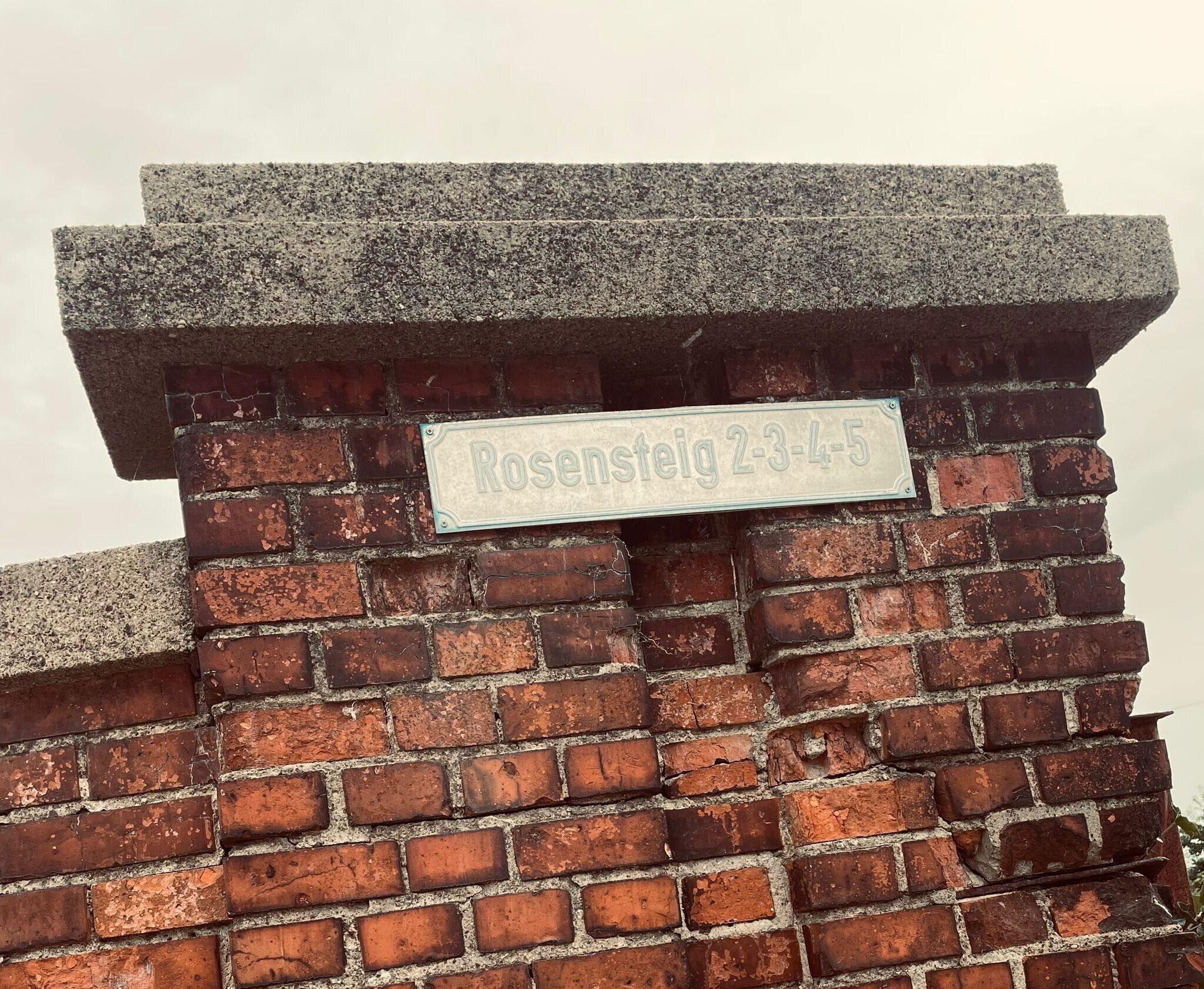 Un mur de briques sur lequel est affiché un panneau indiquant « Rosenstein 2-3-4-5 ».