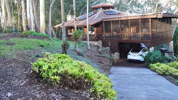 A house with a large deck, surrounded by trees and a garden. - NEWLY LISTED: Secluded Tree House Hideaway 2-bedroom duplex in Honolulu! (Millilani)
