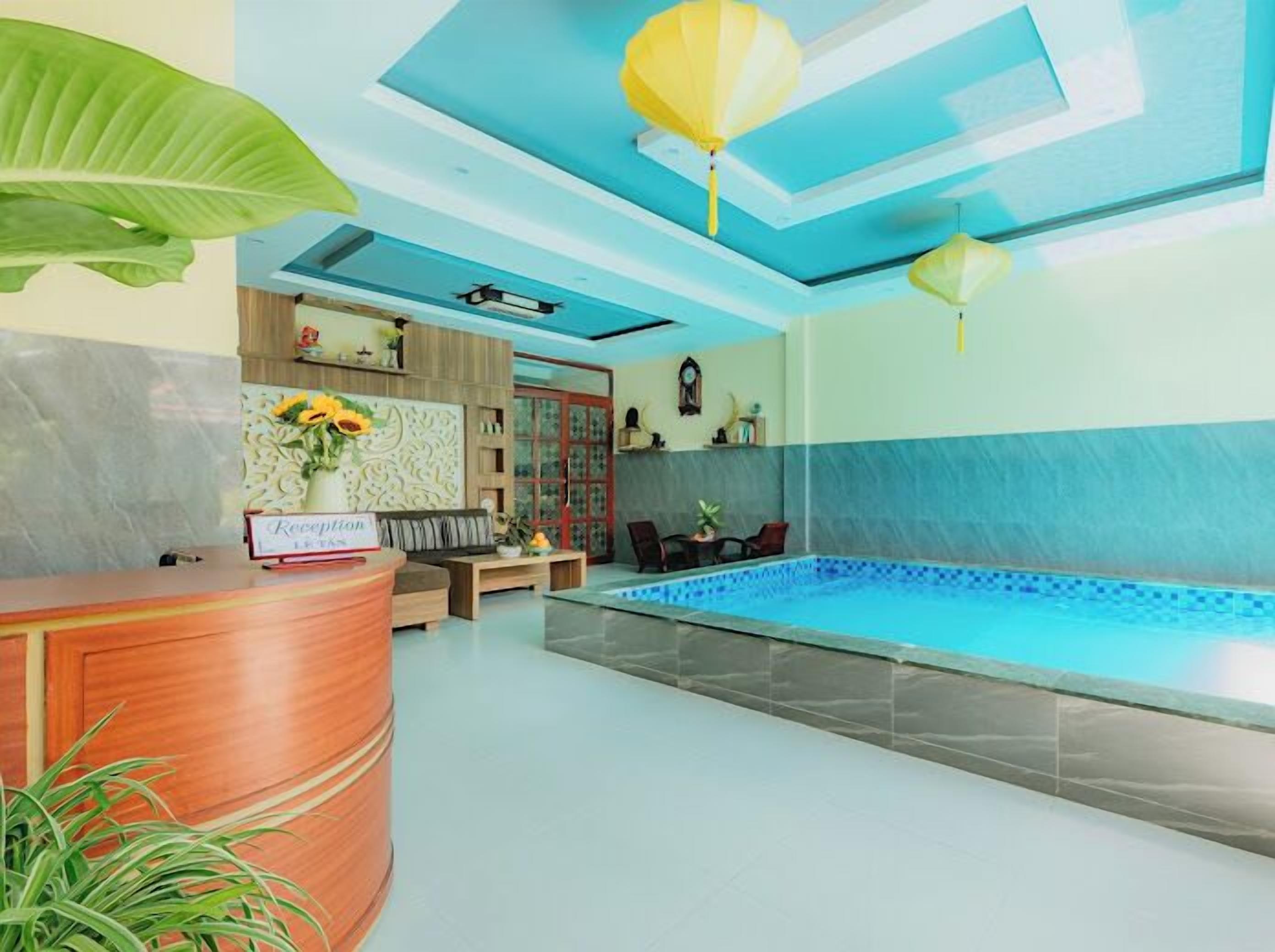 A reception area with a reception desk, a pool, and a seating area with a sofa and chairs.