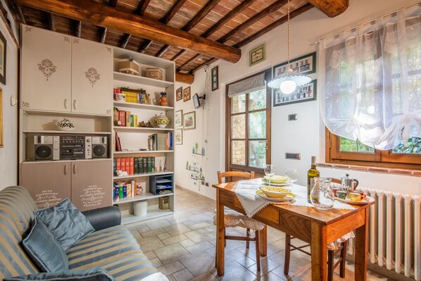 A cozy kitchen with a wooden table, a bookshelf, and a radiator.