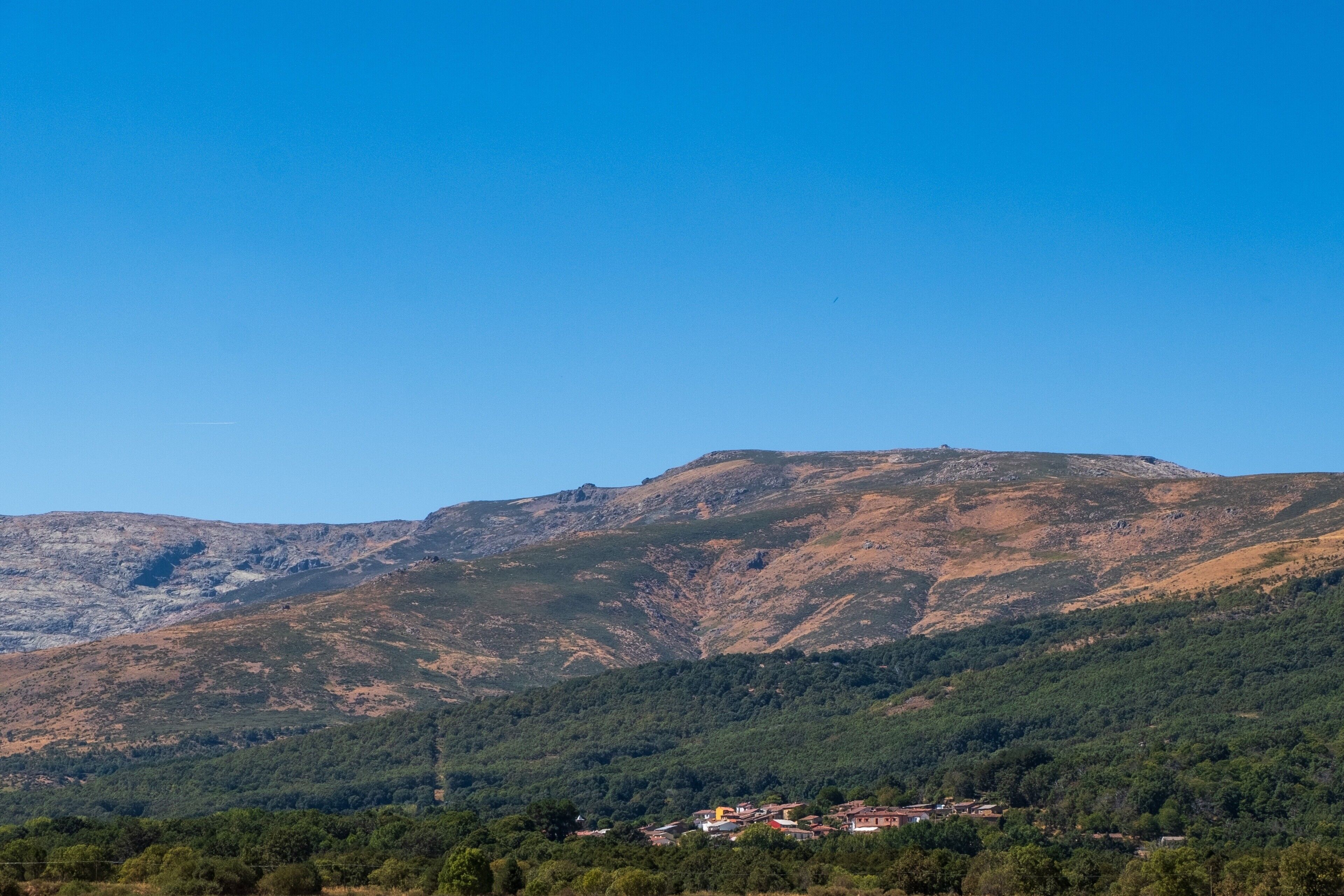 Un paysage montagneux avec un village situé au pied des montagnes.