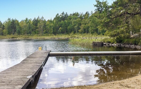 A wooden dock extending into a calm lake, surrounded by dense forest. - 1 bedroom awesome home in Rockneby (Rockneby)