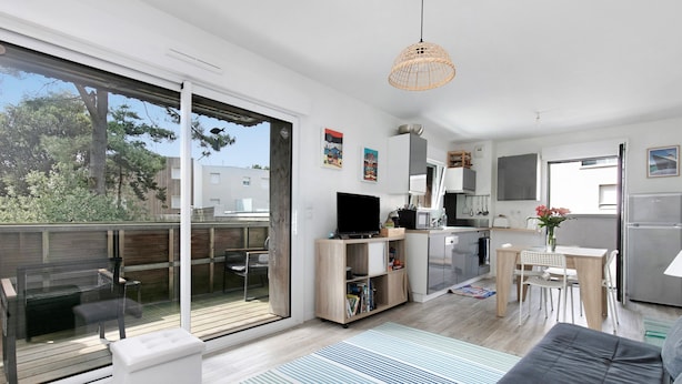 Un appartement moderne doté d’un balcon, d’une cuisine, d’un coin repas et d’un salon.