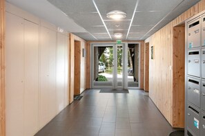 Käytävä, jossa on puupanelointi, lasiovet ja metalliset lokerot.