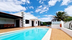 A swimming pool with a white building in the background.