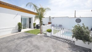 A white building with a tiled roof, a white picket fence, a small lawn, and a pool. - Holiday Home 'Casa Turquesa' with Private Pool, Wi-Fi and Air Conditioning (Conil de la Frontera)