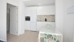 A modern kitchen with white cabinets, a built-in oven, and a marble backsplash. - Holiday Home 'Casa Turquesa' with Private Pool, Wi-Fi and Air Conditioning (Conil de la Frontera)