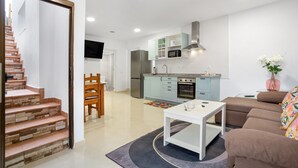 A modern kitchen with light blue cabinets, a stainless steel refrigerator, and a built-in oven.