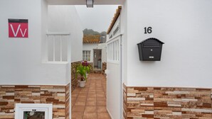 A corridor with a mailbox, a number '16' sign, and a potted plant.