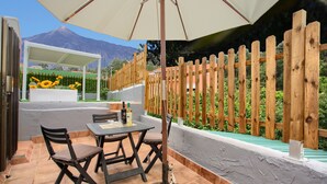 An outdoor patio with a table, chairs, and an umbrella.