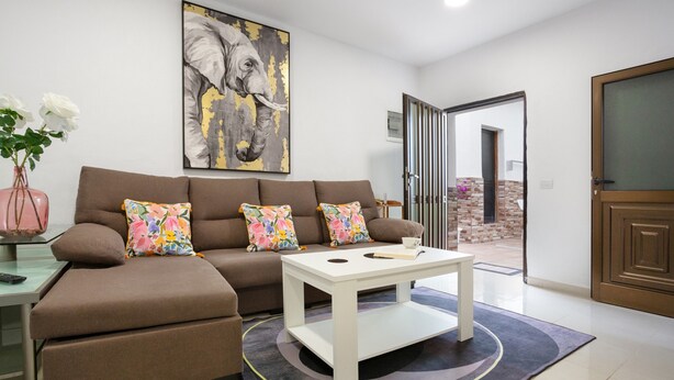 A living room with a sofa, coffee table, and artwork on the wall.