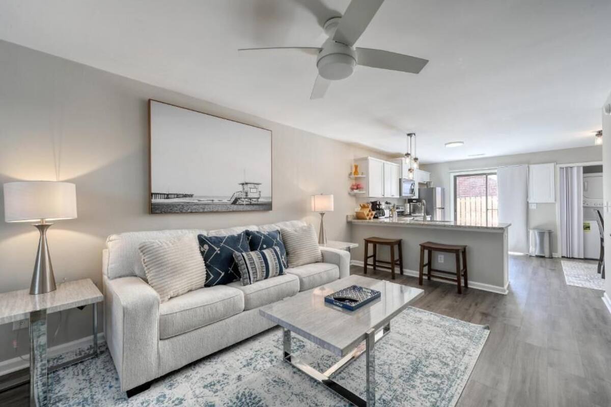 A modern living room with a sofa, coffee table, and a painting on the wall.