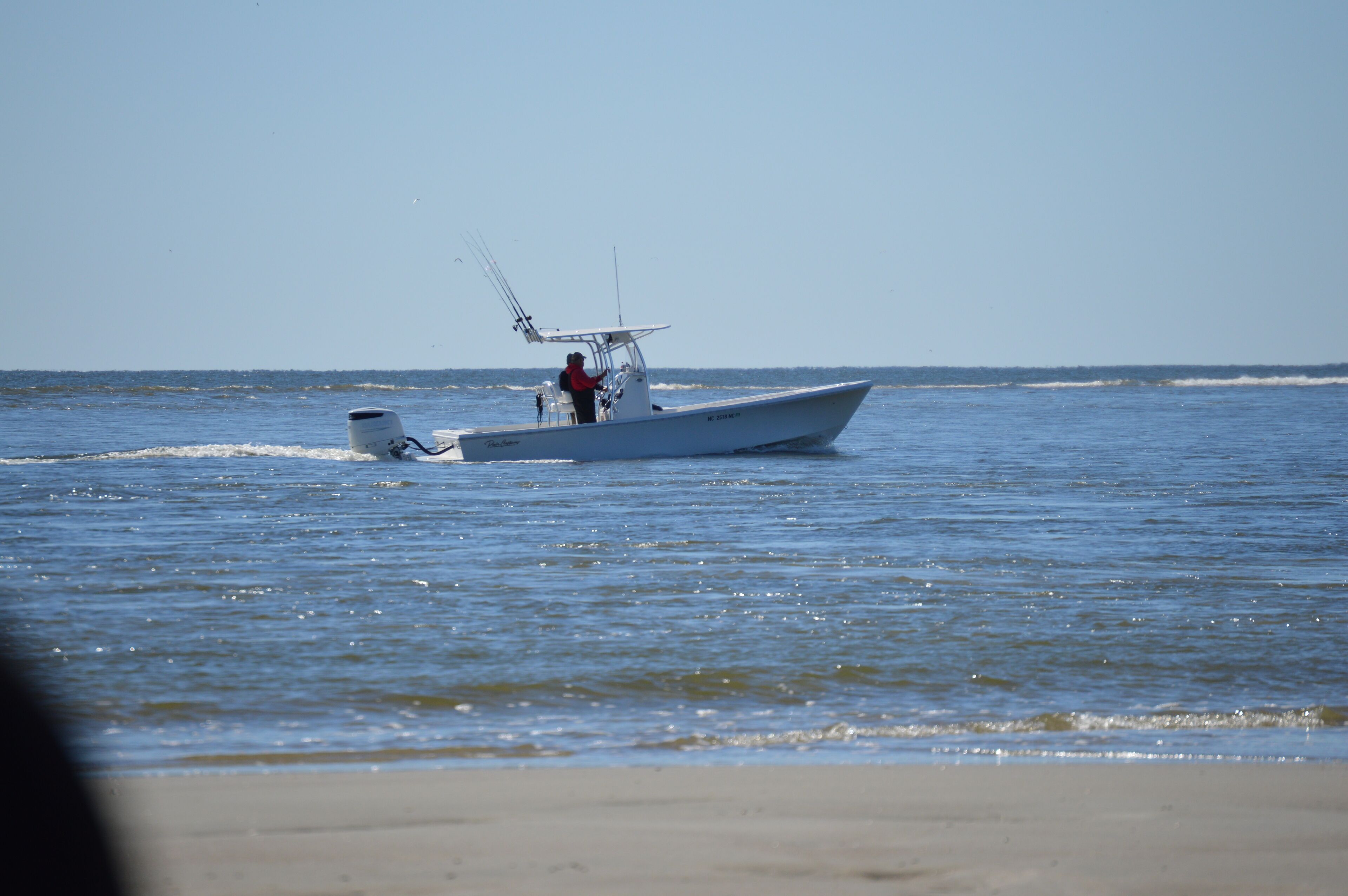 A boat on calm water with a person steering.
