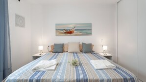 Une chambre à coucher avec un lit, des oreillers, un tableau et des lampes de chevet.