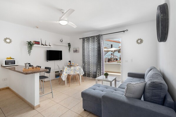 A modern living space with a kitchen, dining area, and seating area.
