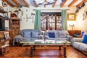 A cozy living room with a sofa, a glass-top coffee table, and a wooden cabinet.