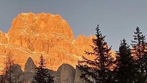 A mountain with a rugged, rocky surface and a clear sky.