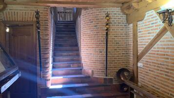 Una escalera de madera con paredes de ladrillo, que conduce a un nivel superior.