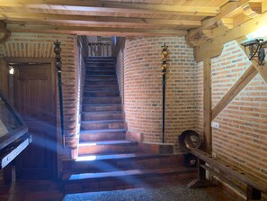 A staircase with wooden steps and brick walls, leading to an upper level.
