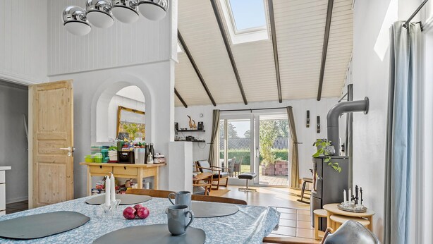 Ein geräumiges Zimmer mit Essbereich, einer Küche und Blick auf den Garten.