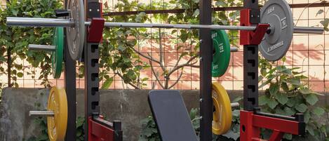 A weightlifting station with various weight plates and a bench.