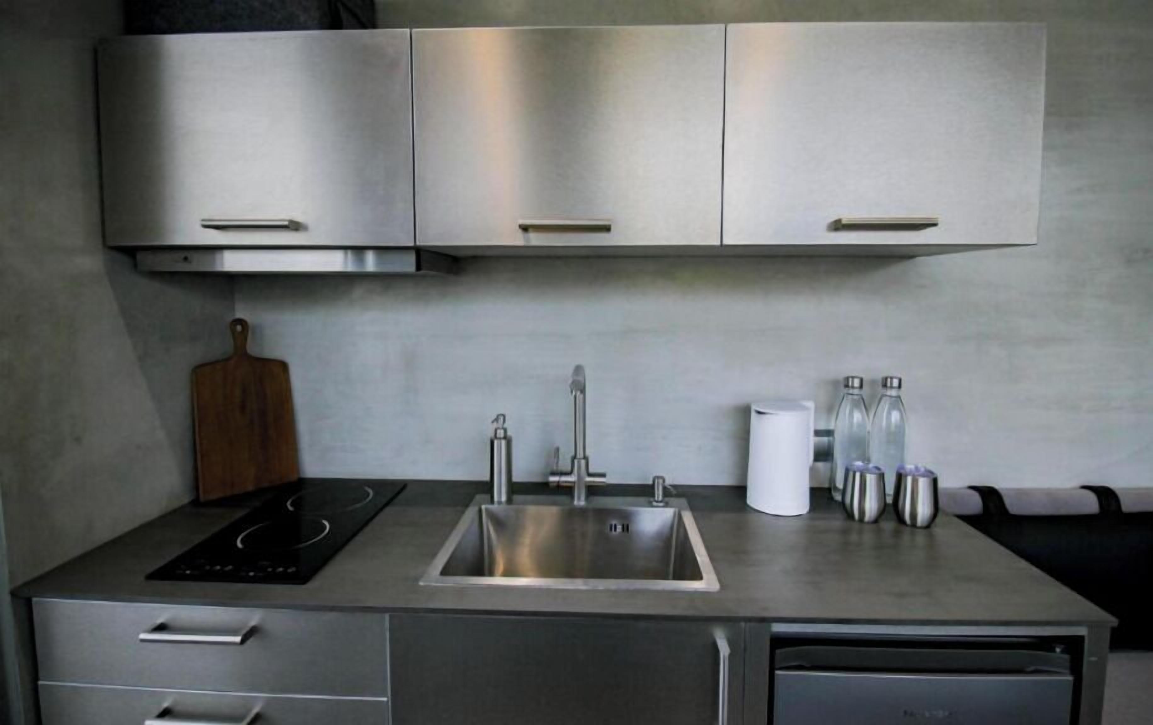 A modern kitchen with stainless steel cabinets, a sink, and a built-in stovetop.