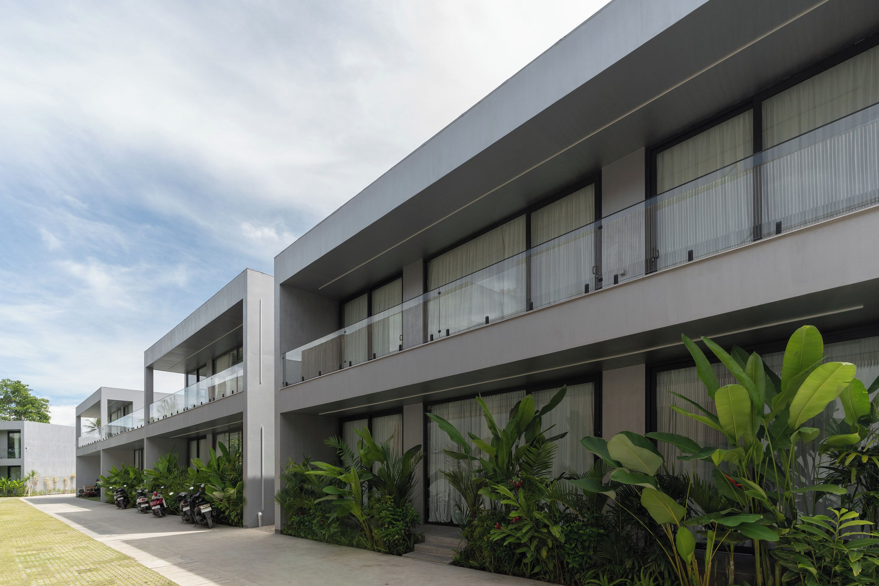 Un edificio moderno con varios pisos, amplias ventanas y techo plano.