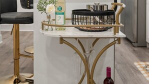 Une cuisine moderne avec un plan de travail en marbre, une bouteille de vin et un panier.