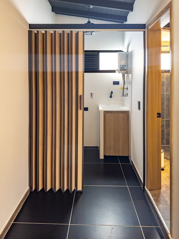 A modern bathroom with a wooden sliding door, a sink, and a mirror.