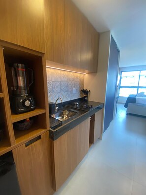 Estudio superior, vista a la ciudad | Cocina privada | Refrigerador, microondas, parrilla de estufa y utensilios de cocina 