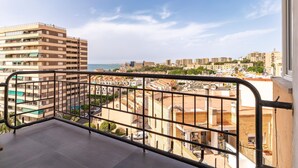 A balcony with a view of a cityscape and the sea.
