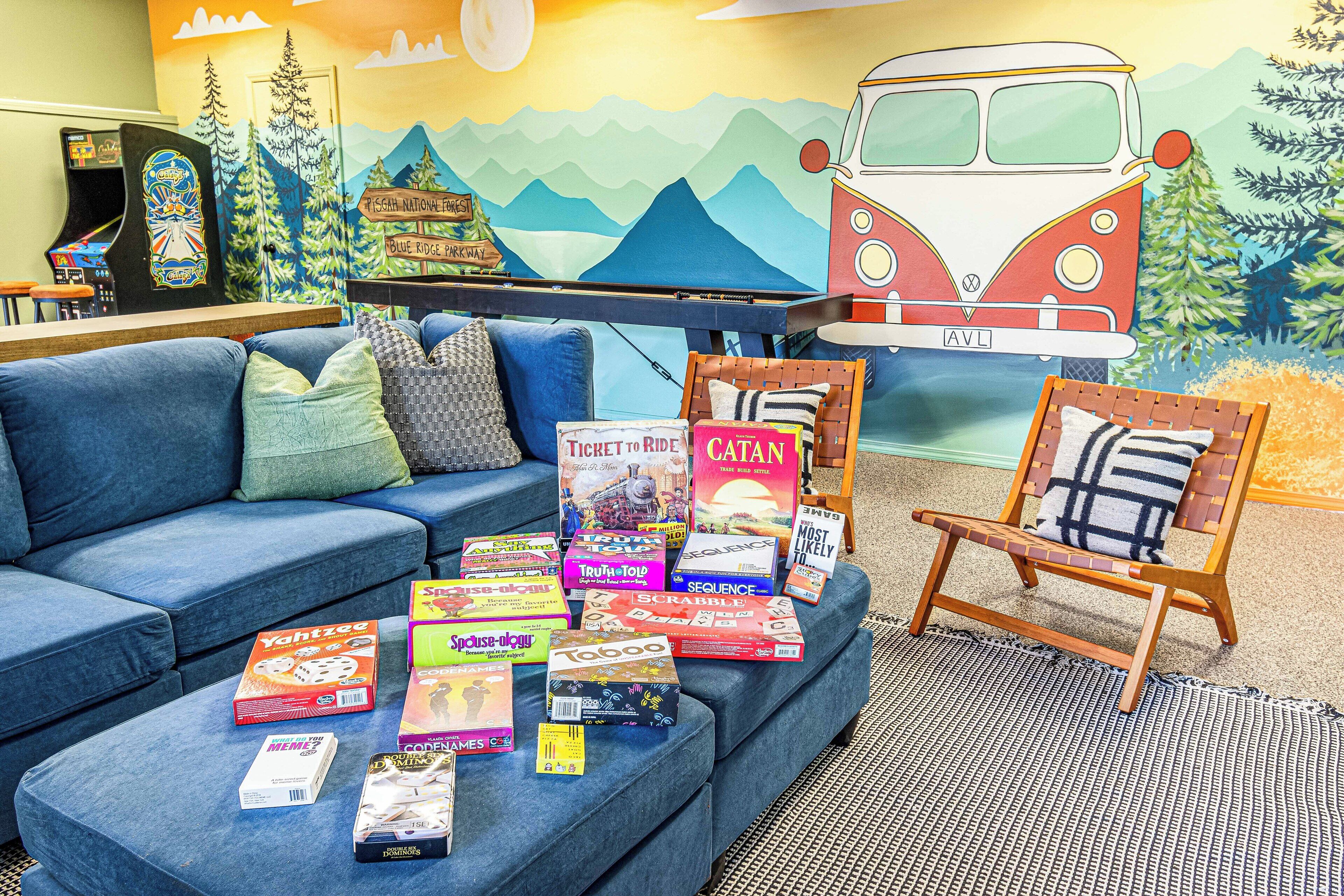 Een knus interieur met een blauwe bank, een houten stoel en een boekenplank vol boeken en spellen.