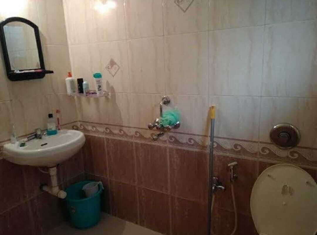 Un baño con lavamanos, espejo, inodoro y ducha.
