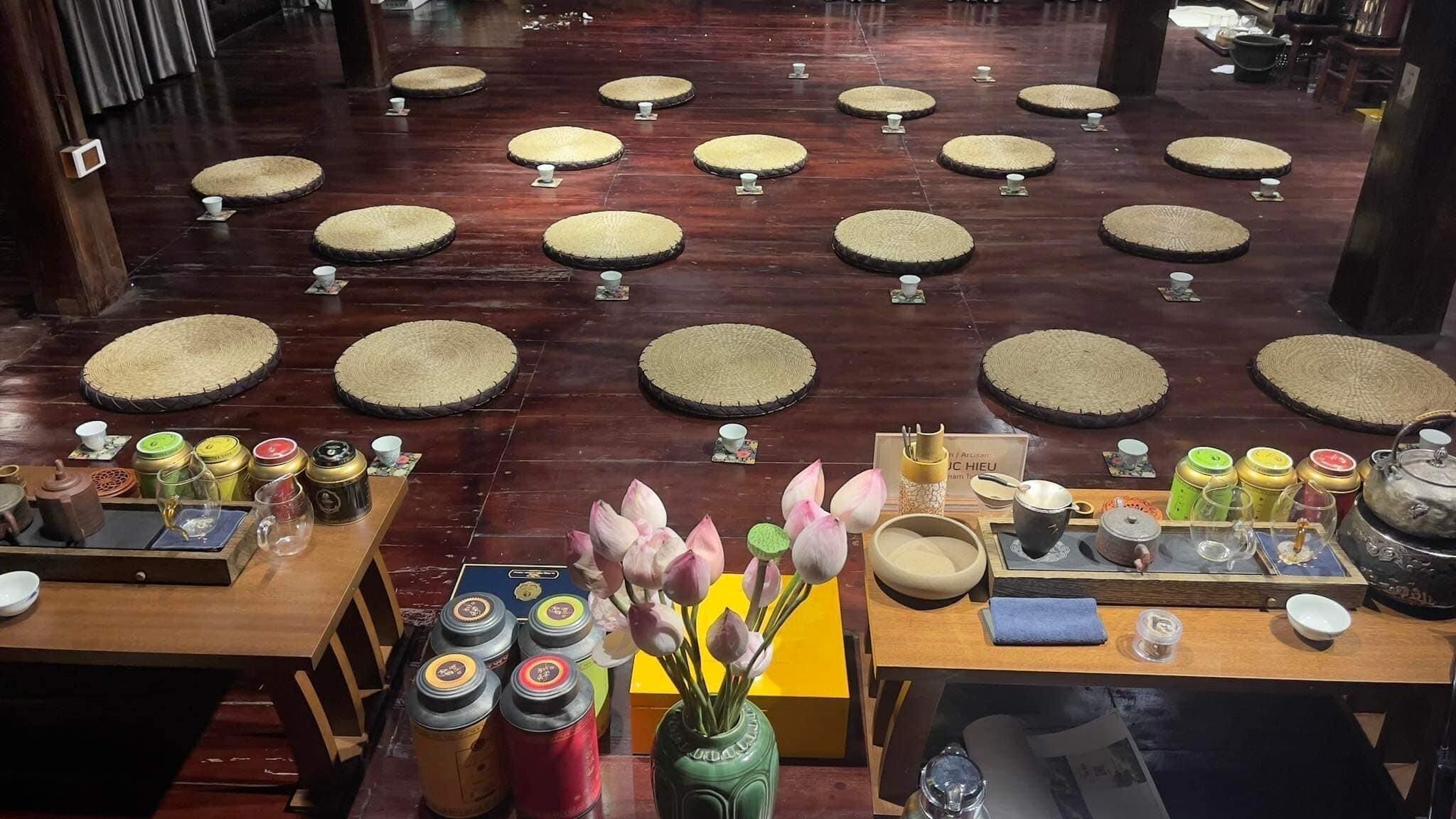 A traditional tea ceremony room with tatami mats, tea sets, and a display of tea containers.