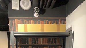 A corner bookshelf with multiple shelves filled with books.