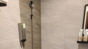 A modern bathroom with a shower, toilet, and sink.