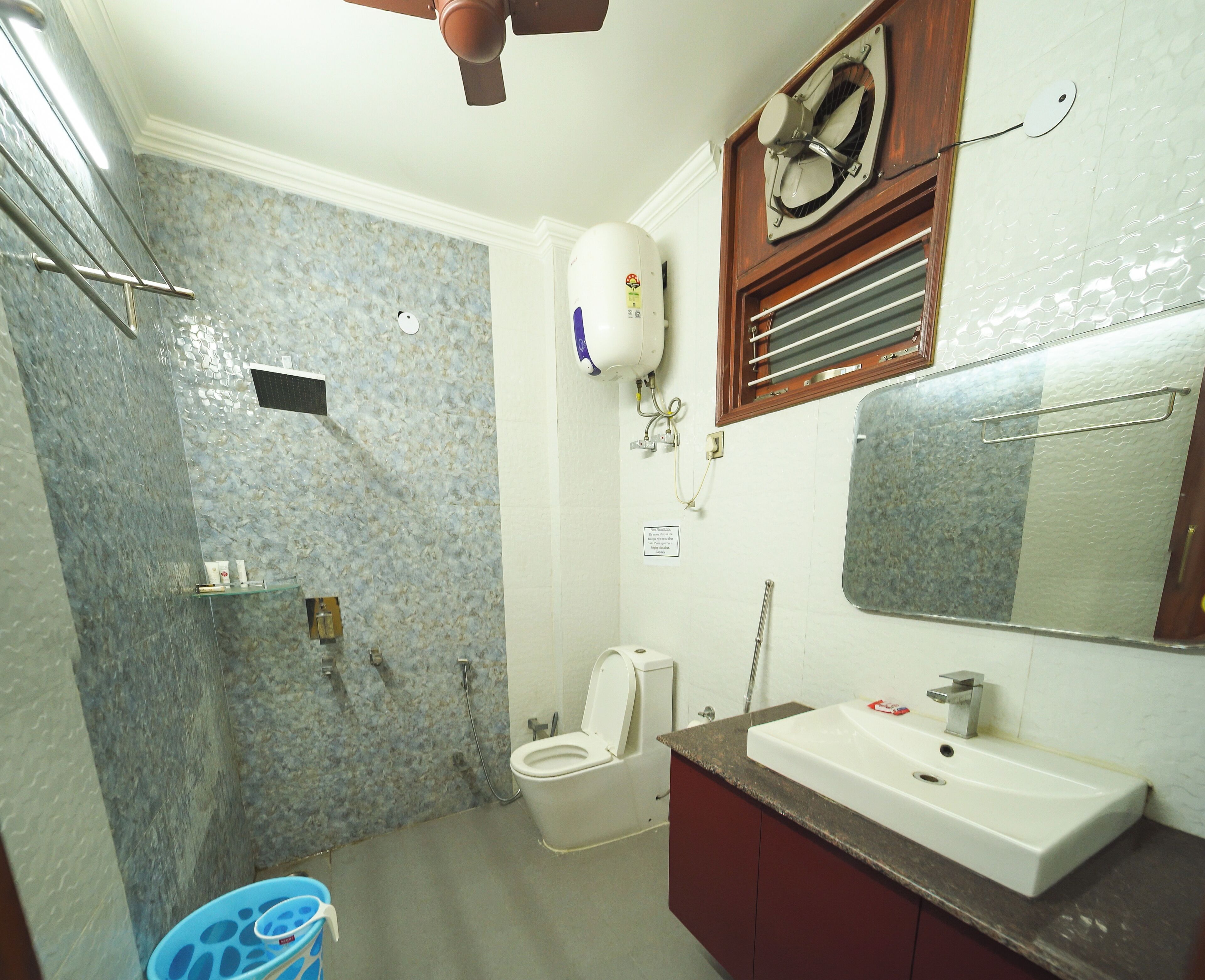 Un baño con ducha, inodoro, lavamanos y espejo.