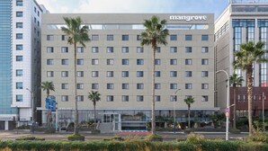 A multi-story hotel with a modern design, featuring a prominent 'Mangrove' sign on the facade. - Mangrove Jeju City (Jeju City)