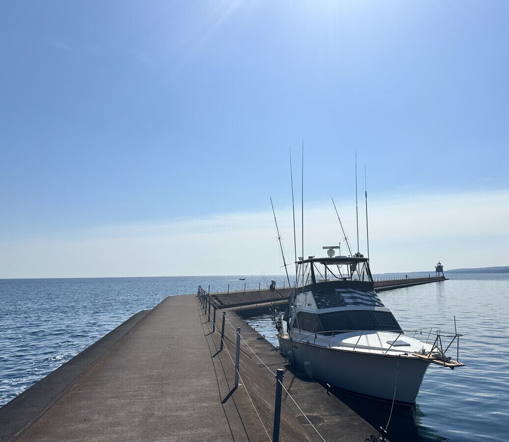 Un bateau était amarré à un quai qui s’étendait dans des eaux calmes.