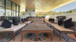 A covered outdoor seating area with wicker furniture and a patterned rug. - Zhiwaling Ascent (Thimphu)
