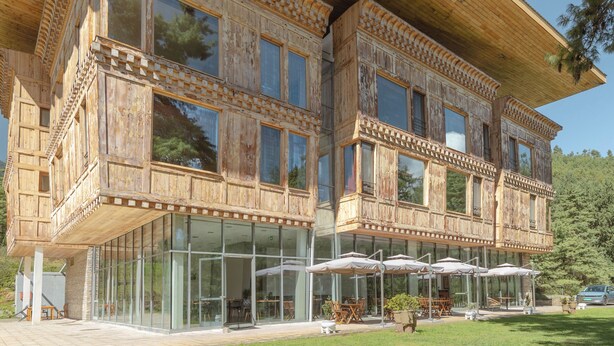 A wooden building with large windows and outdoor seating. - Zhiwaling Ascent (Thimphu)