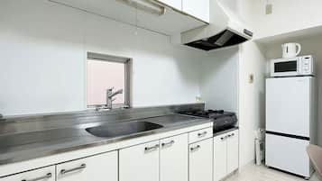 Kylskåp, mikrovågsugn, spishäll och grytor/köksredskap