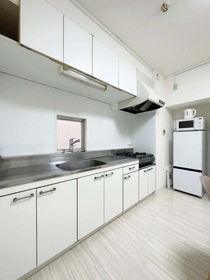 Frigorífico, microondas, placa de cocina y utensilios de cocina