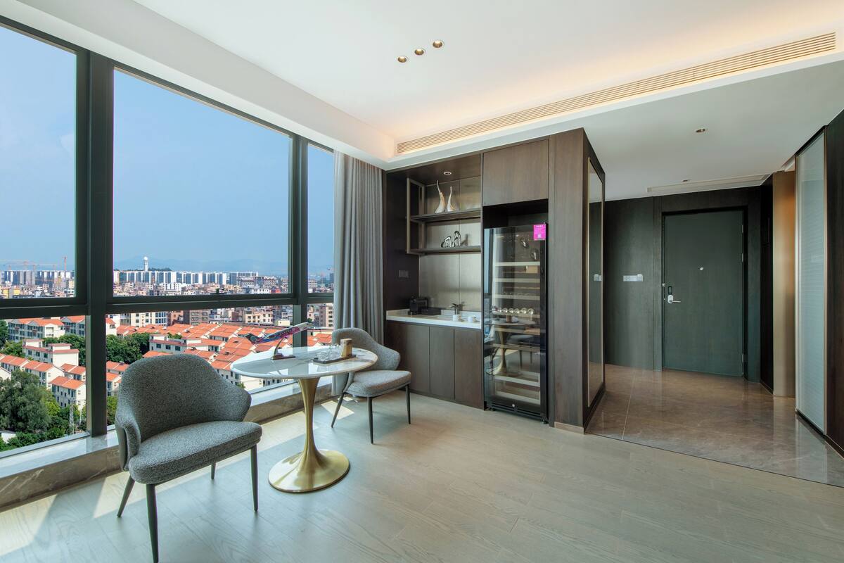 Een moderne woonkamer met stadszicht, een eethoek en een keuken.
