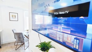 A modern office space with a large glass wall displaying a cityscape illustration, a desk with a chair, and a potted plant. - Entire rental unit in Niagara Falls,Free parking (Niagara Falls)
