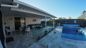 A covered patio with a pool, outdoor seating, and potted plants. - Great Family & Pet-Friendly Getaway, Sleeps 8 (Forest Lake)