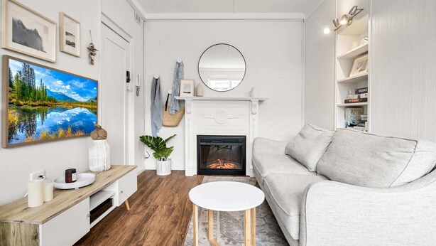 Un salon avec une cheminée, un canapé, une table basse et un téléviseur.