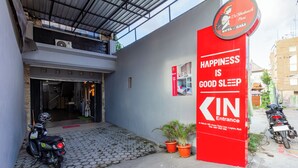 A building entrance with a red sign stating "Happiness is good sleep" and a motorcycle parked outside. - Collection O Seminyak Near Seminyak Beach Formerly De Shabach (Legian)
