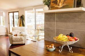 A room with a wooden table, a wicker fruit basket, and a bowl of eggs. - Trawalla - an entire house & pool bar - GREAT FOR GROUPS (Gundaroo)