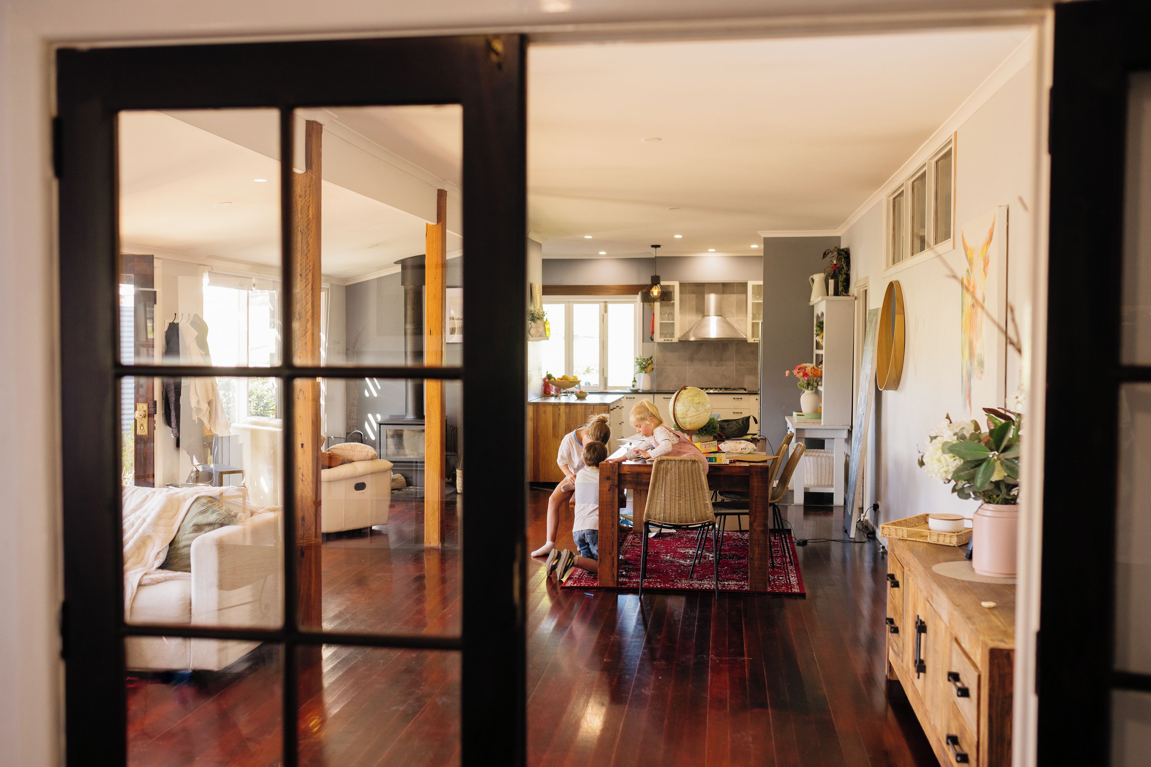 An interior view of a home with a dining area, kitchen, and living space.